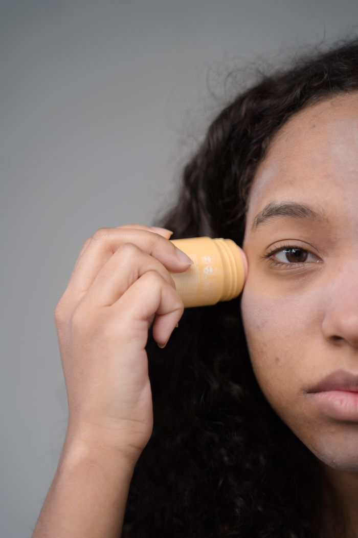 Offerings A woman applies skincare in a close-up half-face view, emphasizing self-care.